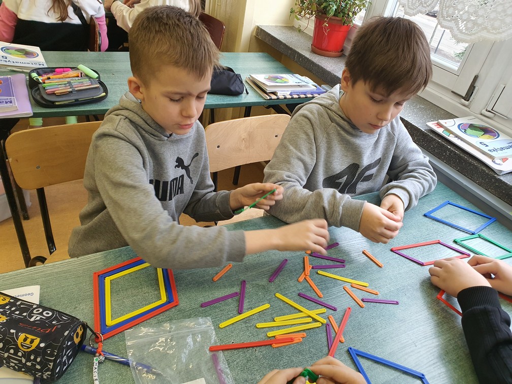 Chłopcy konstruują romby różnej wielkości.