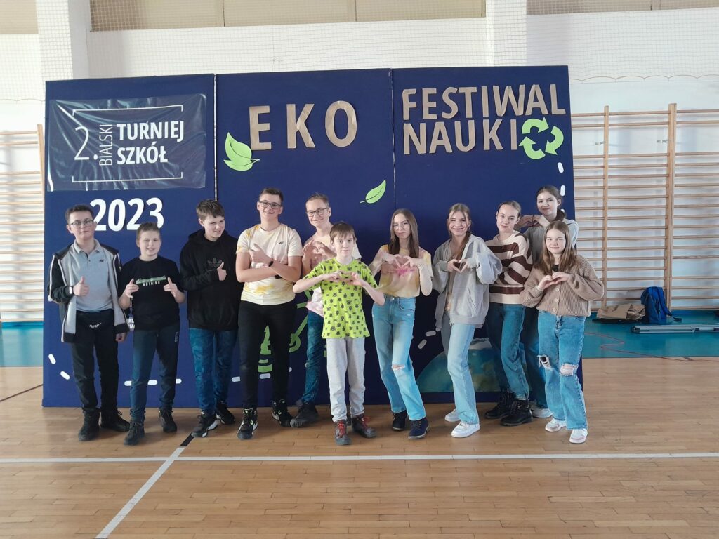 Uczniowie pozujący do zdjęcia pod hasłem turnieju "Eko Festiwal Nauki"