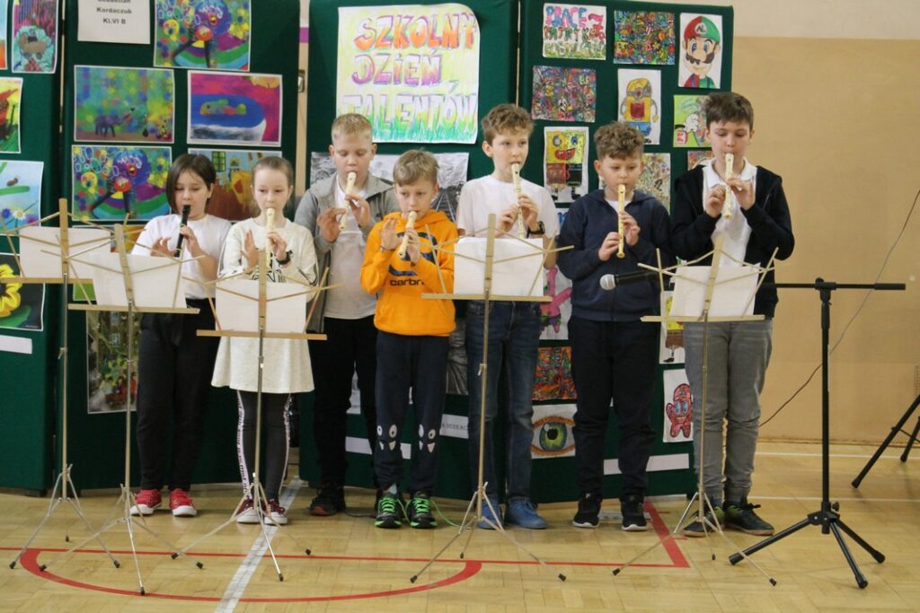 Uczniowie grający na fletach.