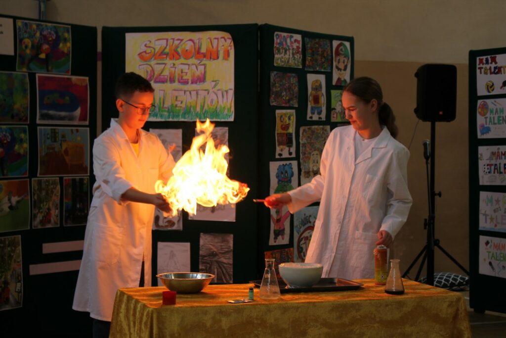 Uczniowie pokazujący eksperyment z ogniem