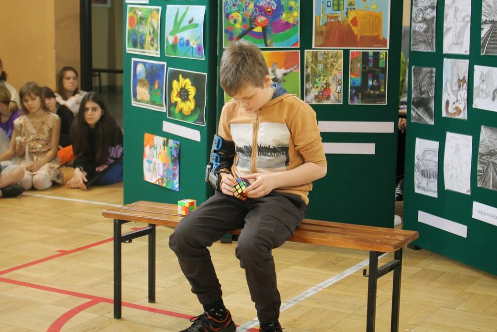 Uczeń układające kostkę Rubika na czas