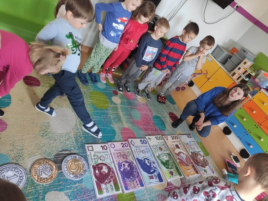 Pięciolatki wskazują banknoty.