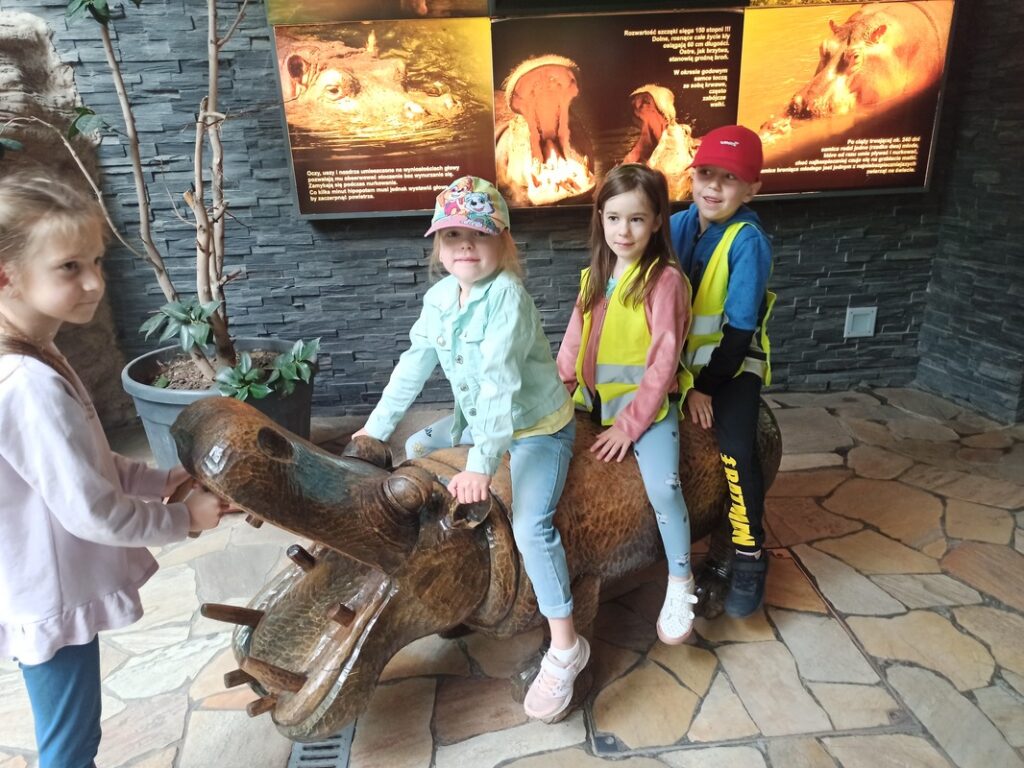 Wiktor, Hania i Julka siedzą na hipopotamie.