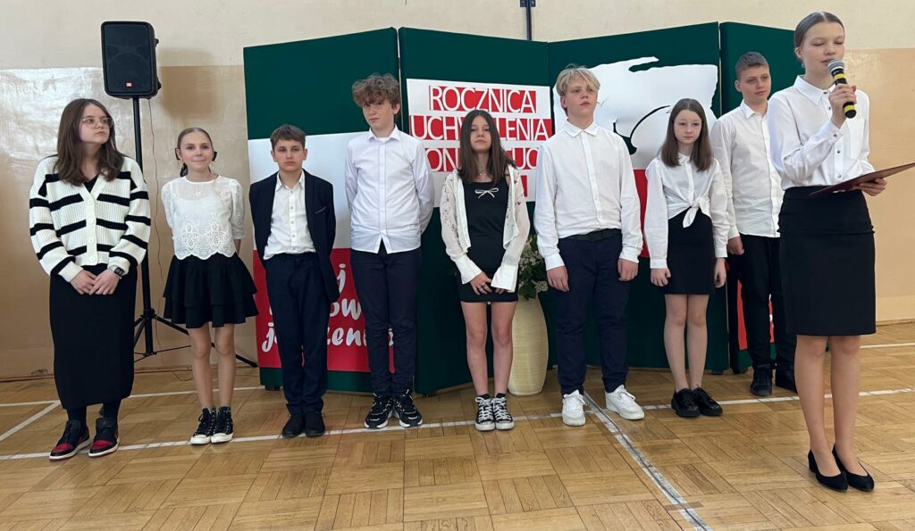 uczniowie występujący podczas akademii oraz prowadząca 