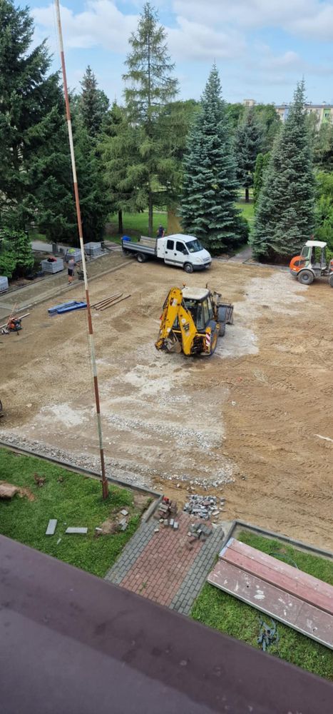 widok z góry na remontowany plac apelowy, widać koparkę i samochód dostawczy