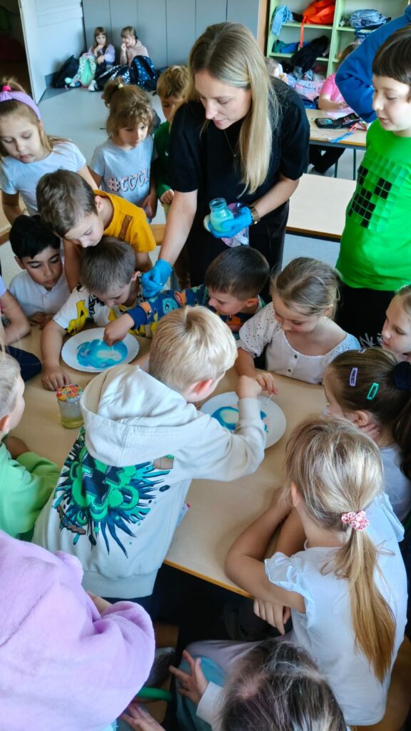 Dzieci wykonują i obserwują odpychanie się cząsteczek barwnika.