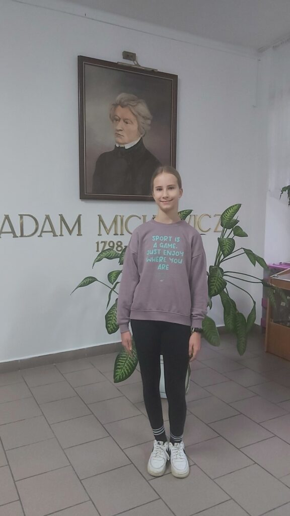 uczennica przy portrecie patrona szkoły