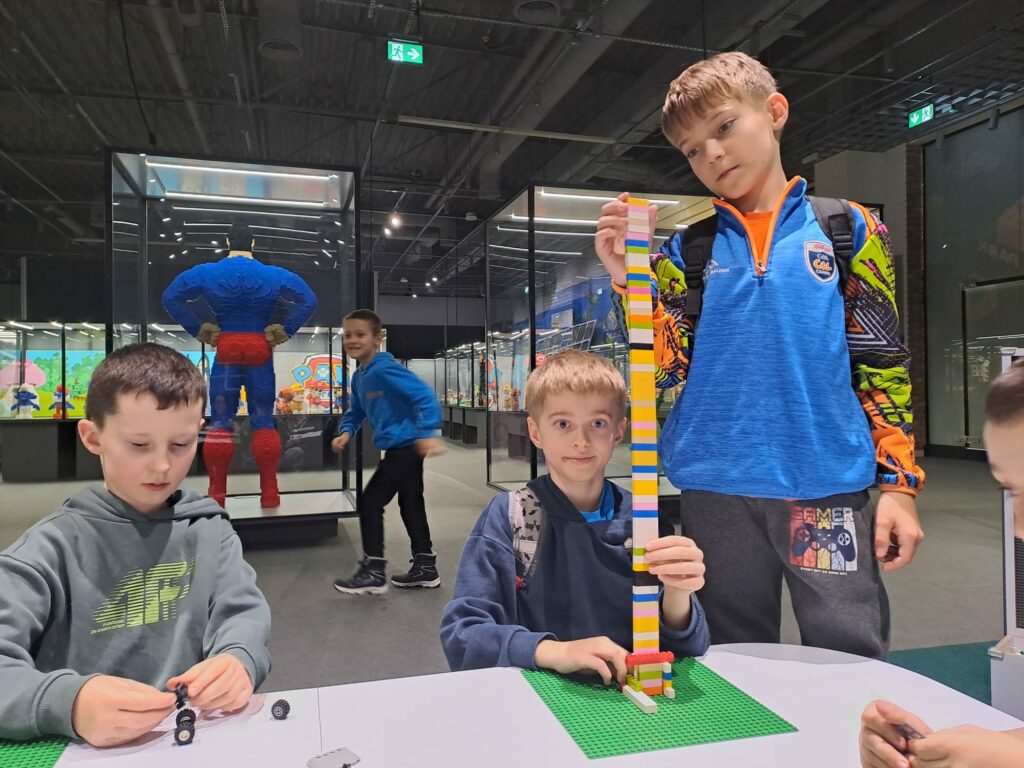 Uczniowie układają wieżę z klocków lego