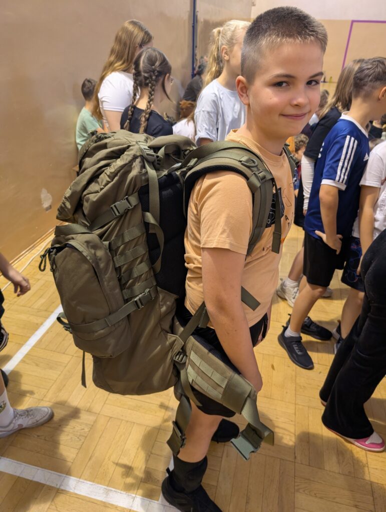 Uczeń prezentuje plecak taktyczny