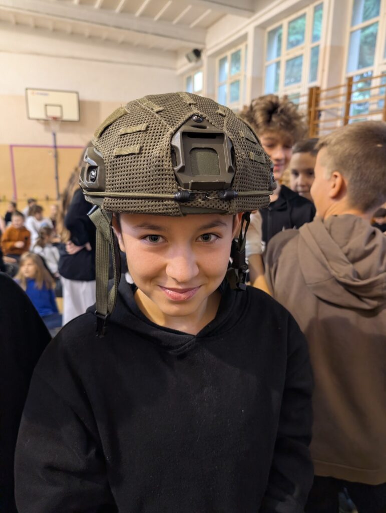 Uczeń prezentuje hełm balistyczny