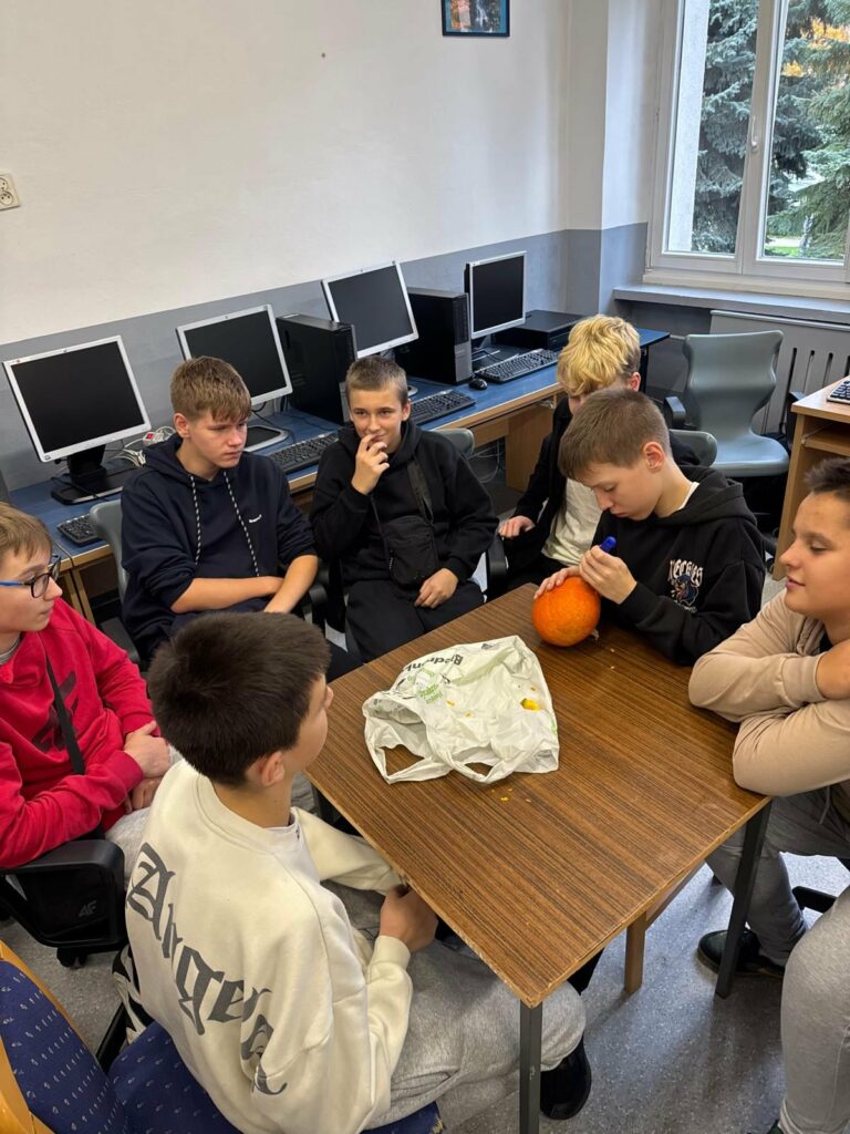 uczniowie wydrążają dynię