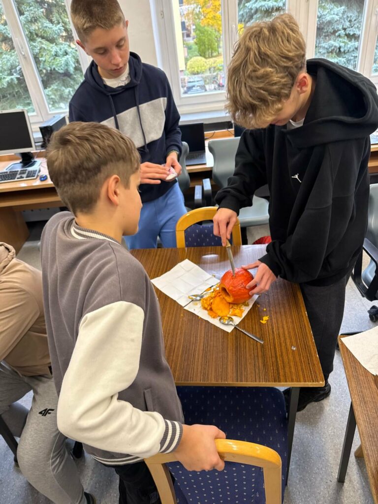 uczniowie wycinają kształt w dyni