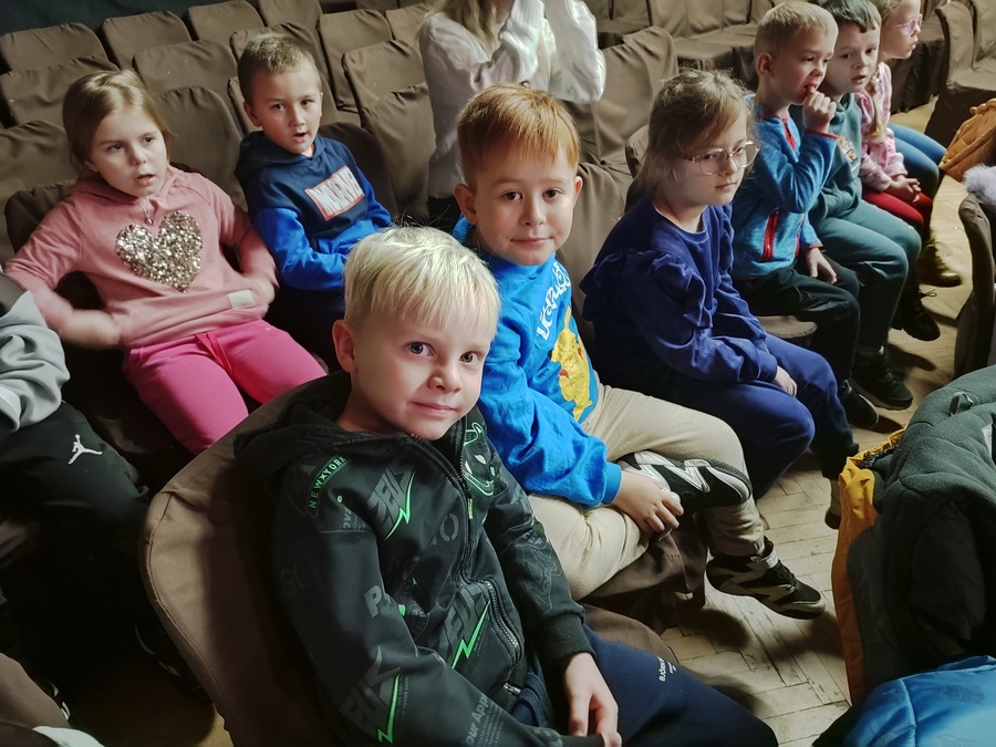 dzieci siedzą na widowni