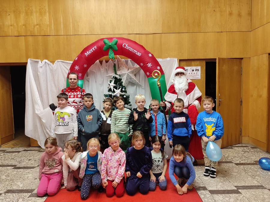 dzieci stoją z Mikołajem