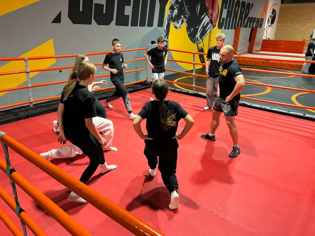 grupa osób wykonująca ćwiczenia w ringu