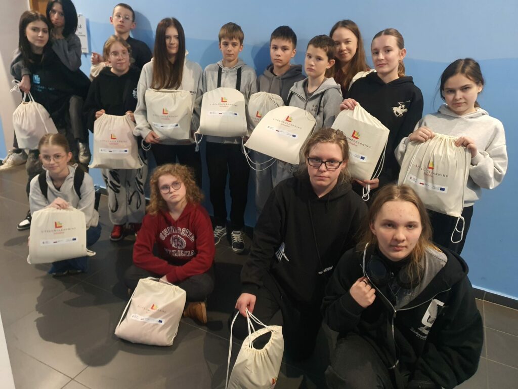 grupa dzieci trzymająca białe worki