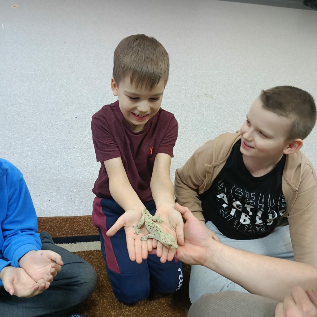 Uczeń trzyma w ręku gada