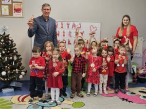 grupa przedszkolaków oraz nauczyciele trzymają Mikołaje, wszyscy stoją