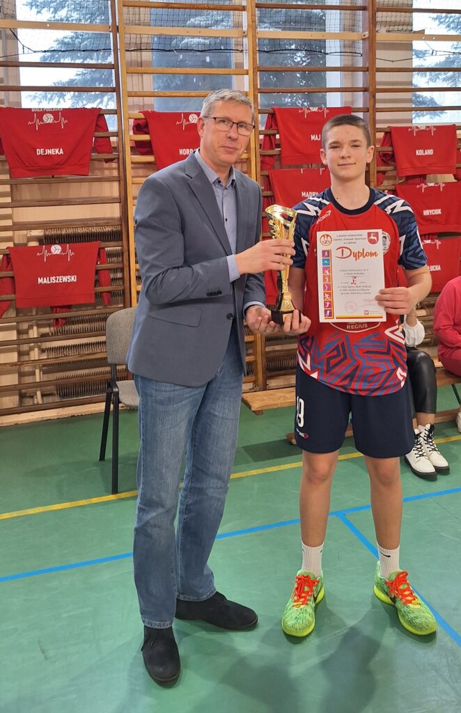 Dyrektor szkoły wręcza puchar kapitanowi naszego zespołu..