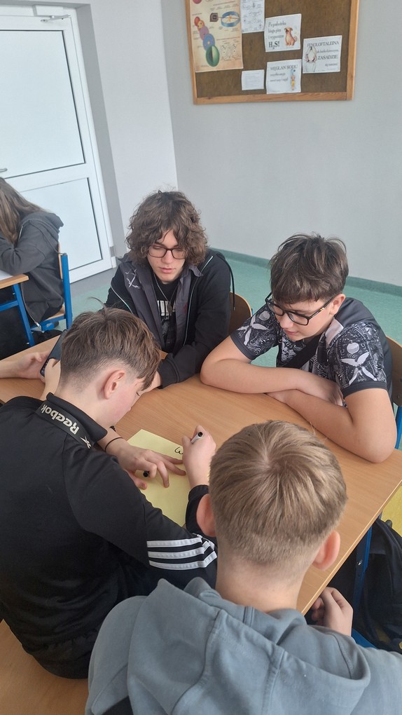 Uczniowie wykonują plakat o wartościach odżywczych pączków.