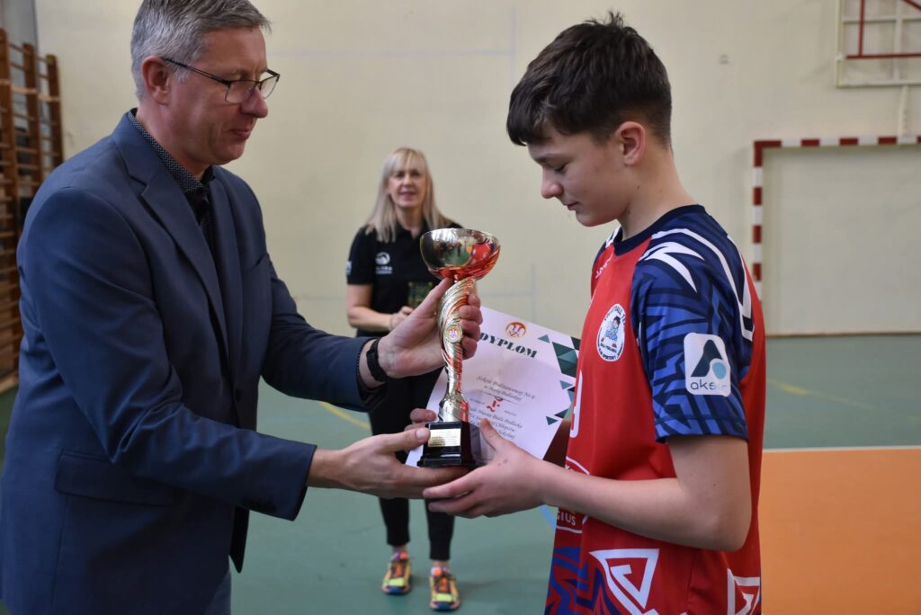 Dyrektor wręcza puchar kapitanowi zwycięskiej drużyny.