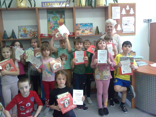 Uczniowie klasy 1a z wypożyczonymi książkami i dyplomami czytelnika 1