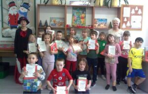 Klasa 1 a demonstruje wypożyczone książki i dyplomy czytelnika