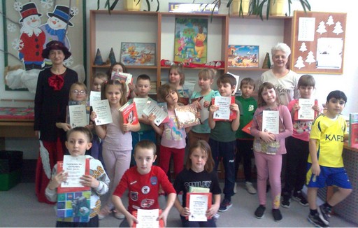 Klasa 1 a demonstruje wypożyczone książki i dyplomy czytelnika