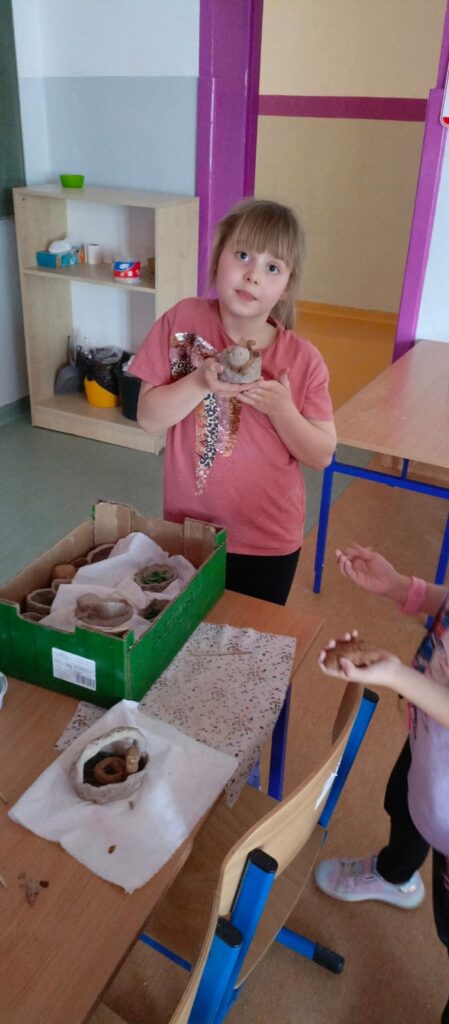 Uczennica prezentuje swoje gliniane zwierzątko