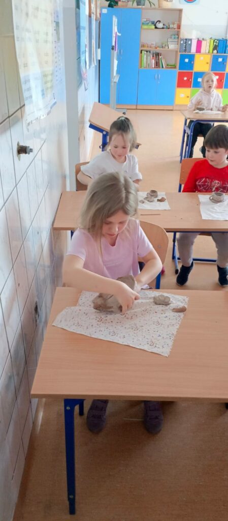 Uczniowie podczas formowania przedmiotów z gliny