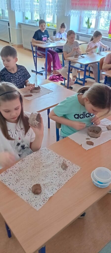 Uczennice formują przedmioty z gliny