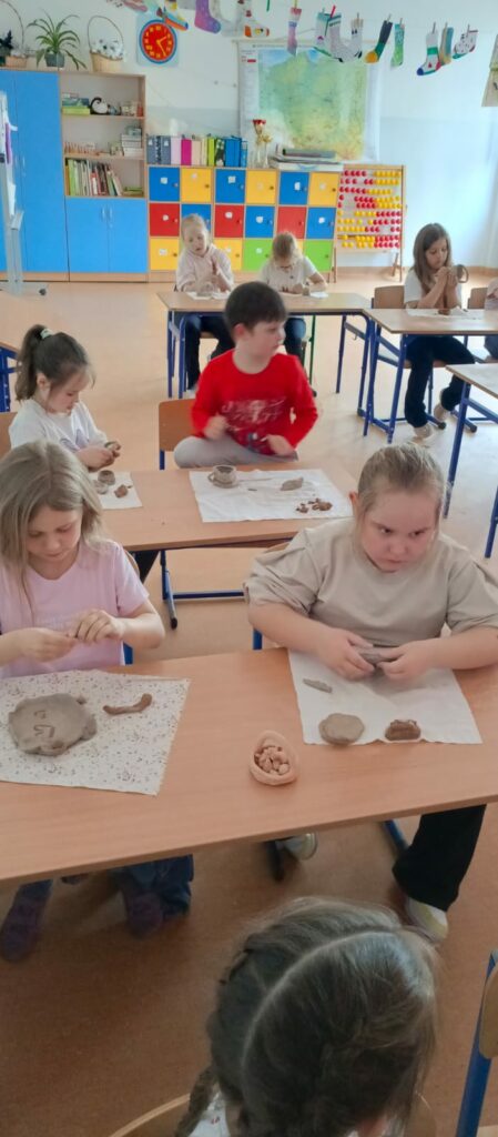 Uczniowie lepią gliniane naczynia