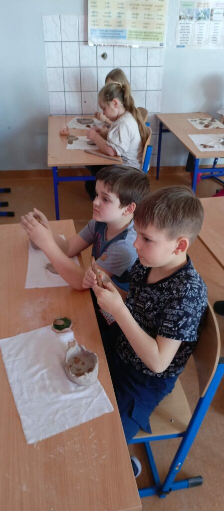 Uczniowie rzeźbią w glinie