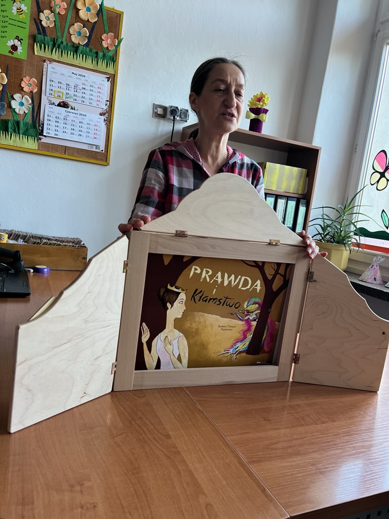Pani z biblioteki przedstawia teatrzyk kamishibai