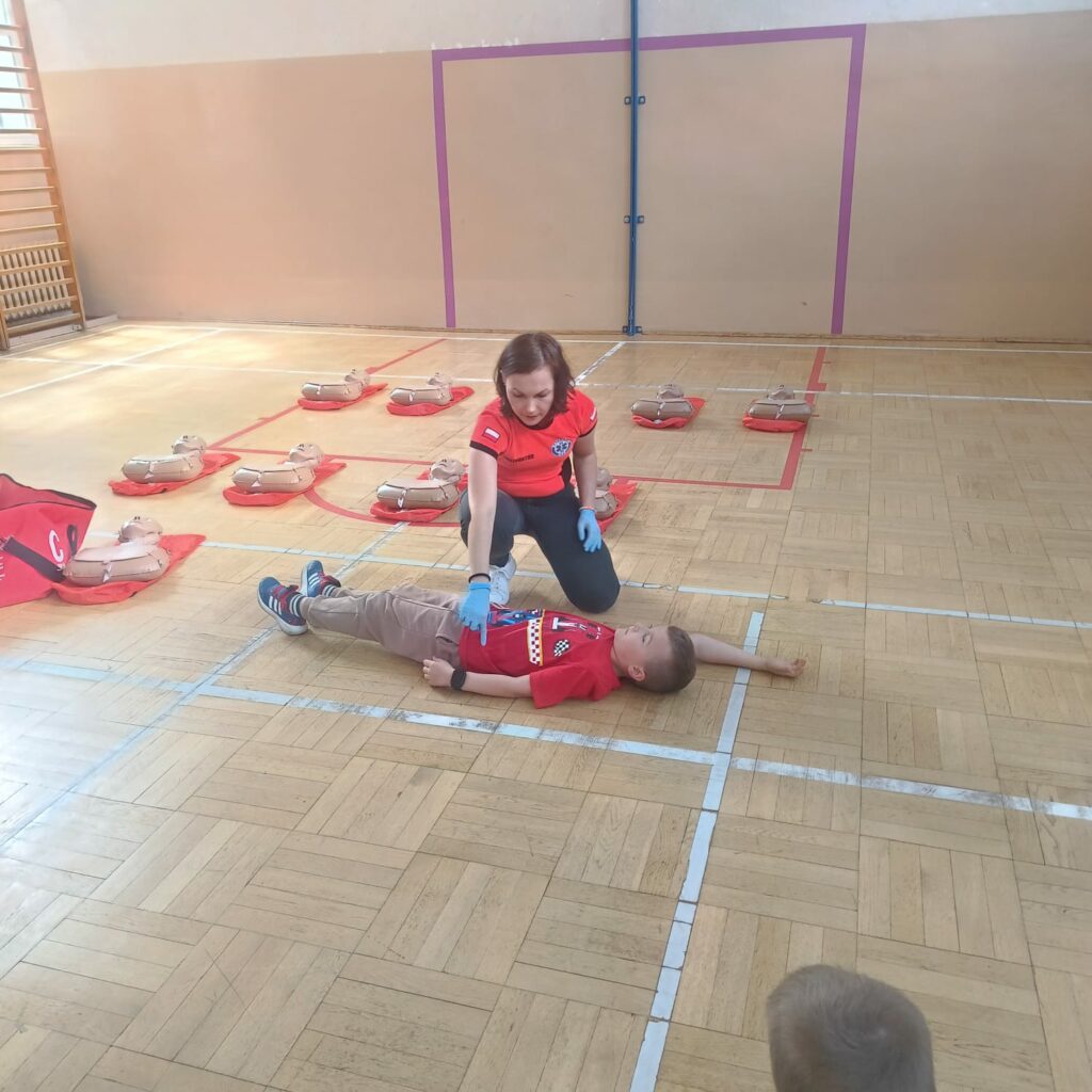 Instruktor demonstruje, jak wygląda pozycja bezpieczna
