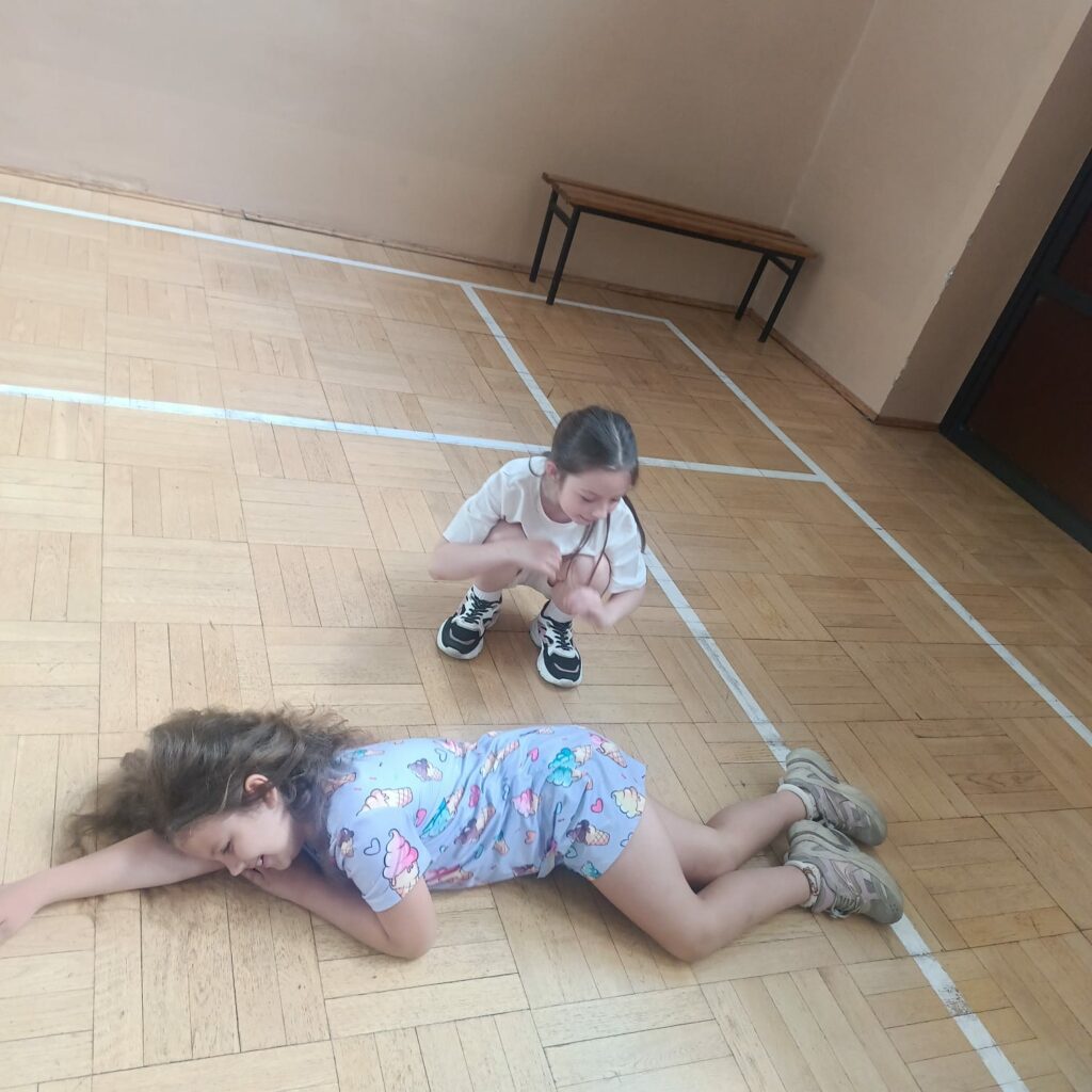 Uczniowie demonstrują, jak wygląda pozycja bezpieczna