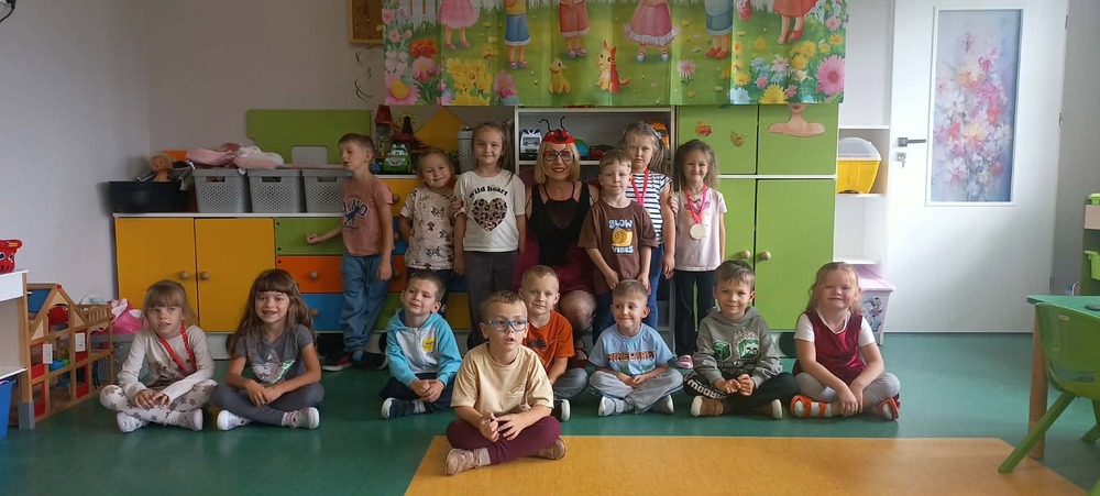 dzieci siedzą na dywanie